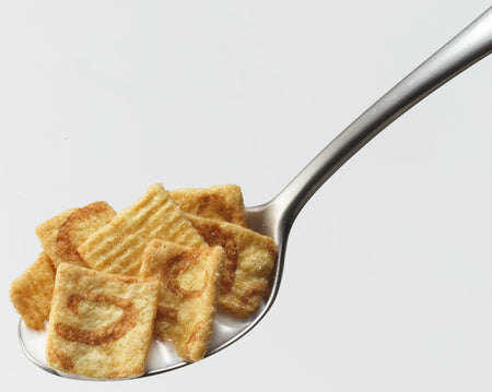 General Mills Cinnamon Toast Crunch Breakfast Cereal on a spoon with milk with a white background