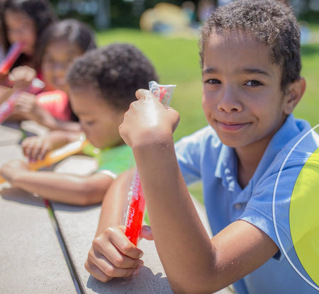 Kids are enjoying Kisko Kids Freezies at the table