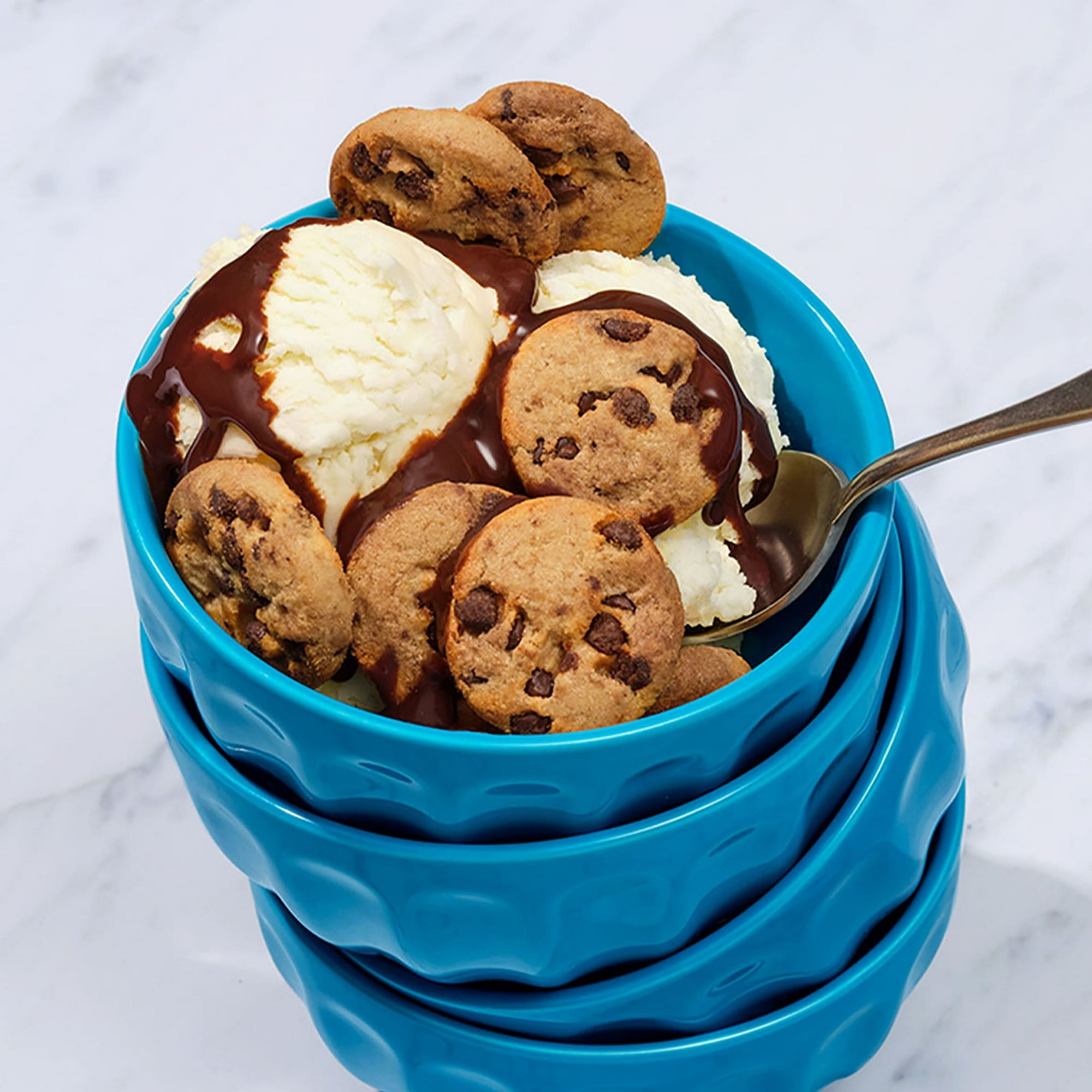 Blue bowl with ice cream and chocolate chip cookies on a marble background
