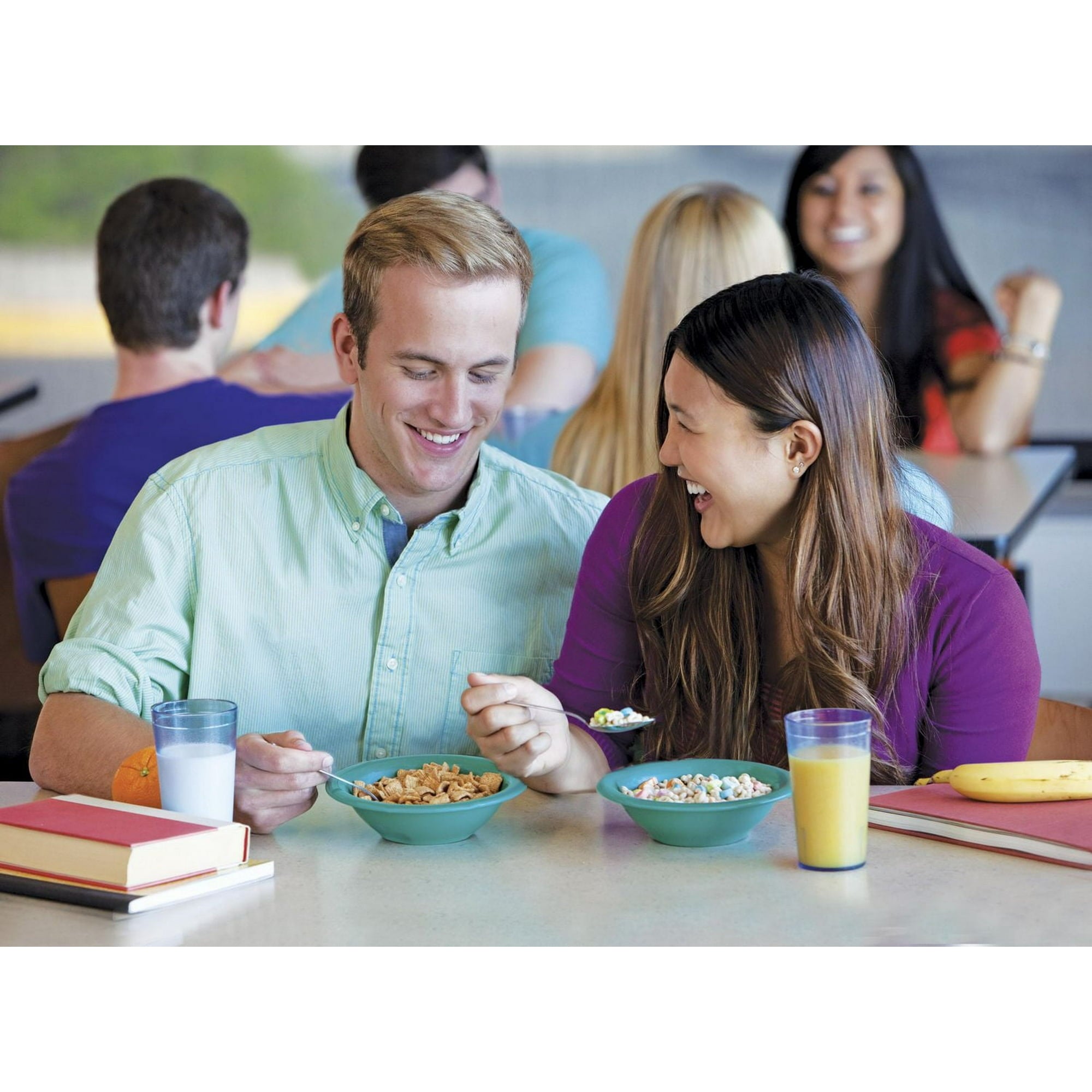 Two people enjoying cereal together at a table with books and drinks.