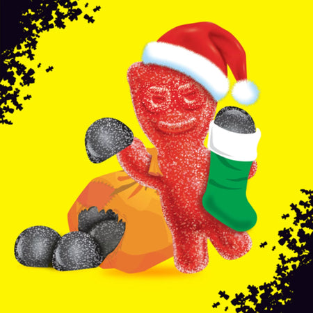 Red Sour Patch Kids gummy kid with a Santa hat and green stocking on a yellow background