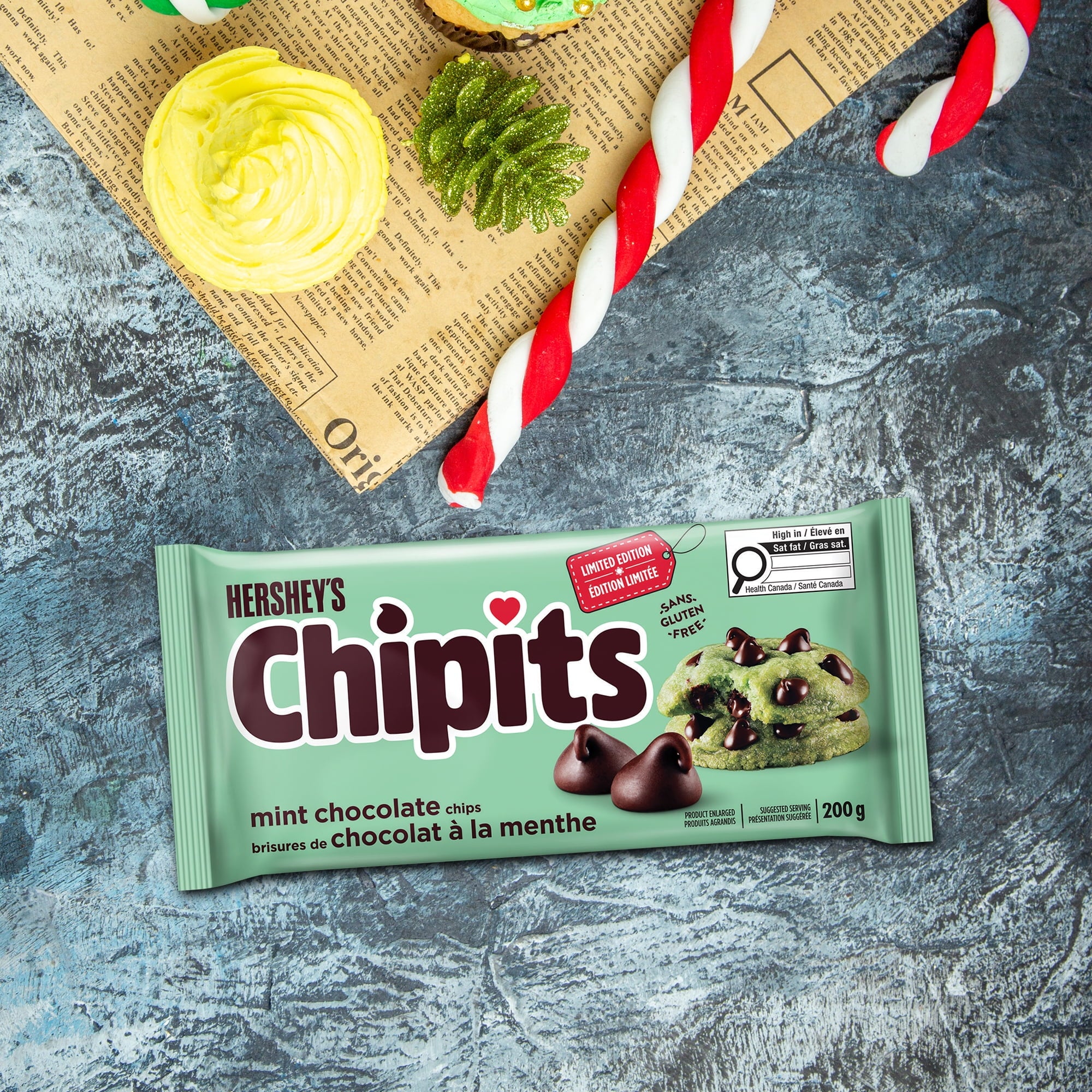 Hershey's Chipits mint chocolate chips packaging on a textured surface with cookies and straws.