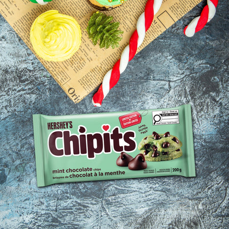 Hershey's Chipits mint chocolate chips packaging on a textured surface with cookies and straws.