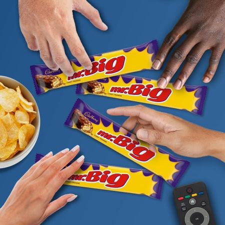 A blue surface with mr.Big candy bars, four hands and a bowl of chips