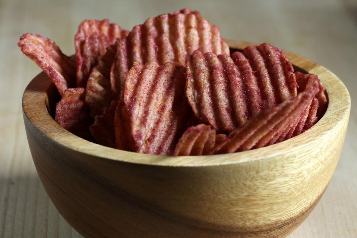 Compliments Extraaa Ketchup Flavor Ridged Potato Chips in a bowl.