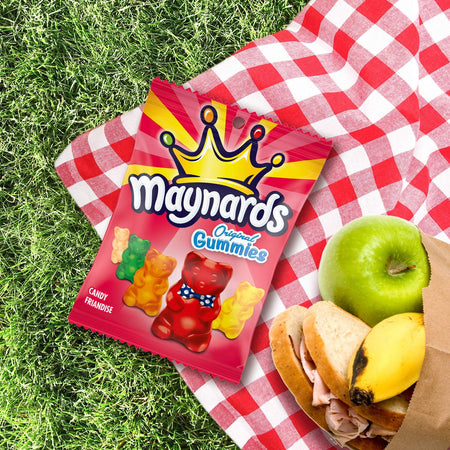 Maynards Original Gummies packet on a red and white checkered blanket with picnic food.