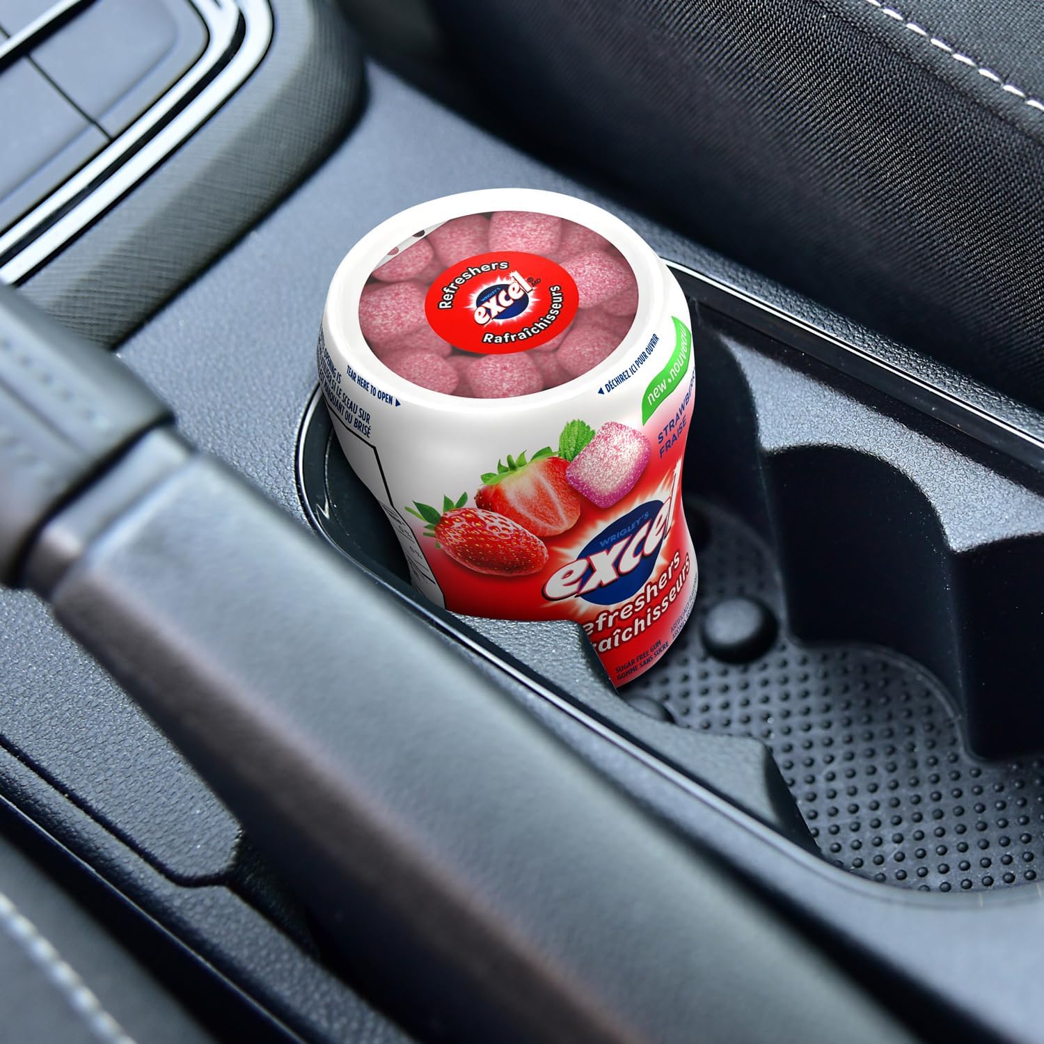 Excel Sugar-Free Gum, Refreshers Strawberry, 6 ct. Package, one bottle in a cup holder in a car.