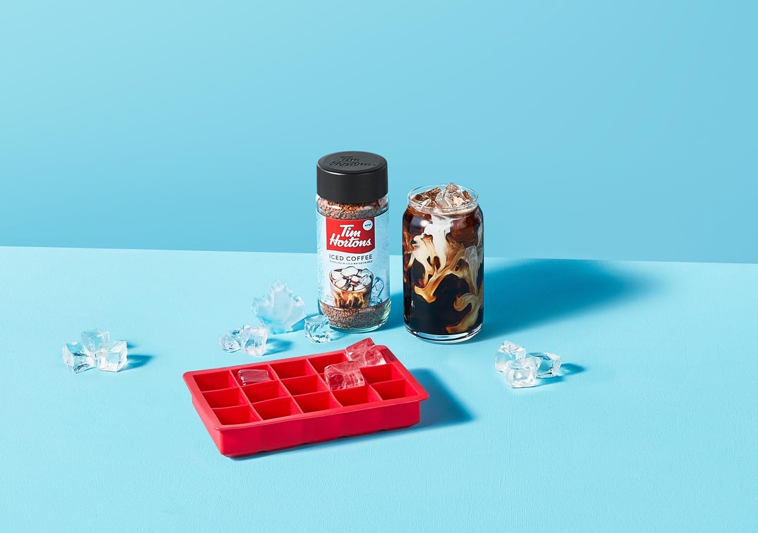 Red ice cube tray with Tim Hortons coffee and iced coffee on a blue background