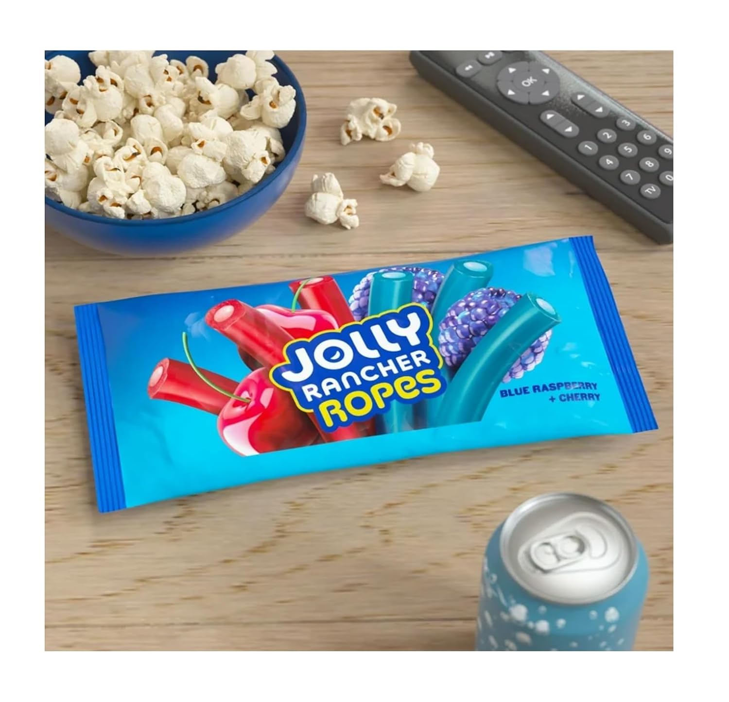 Jolly Rancher Ropes candy package on a table with popcorn and a can of soda.