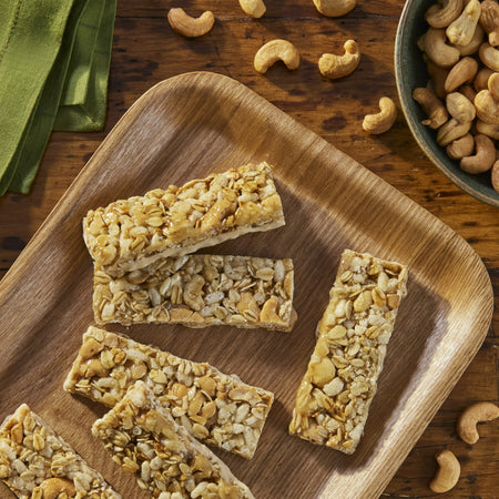 Granola bars on a wooden tray with cashews around