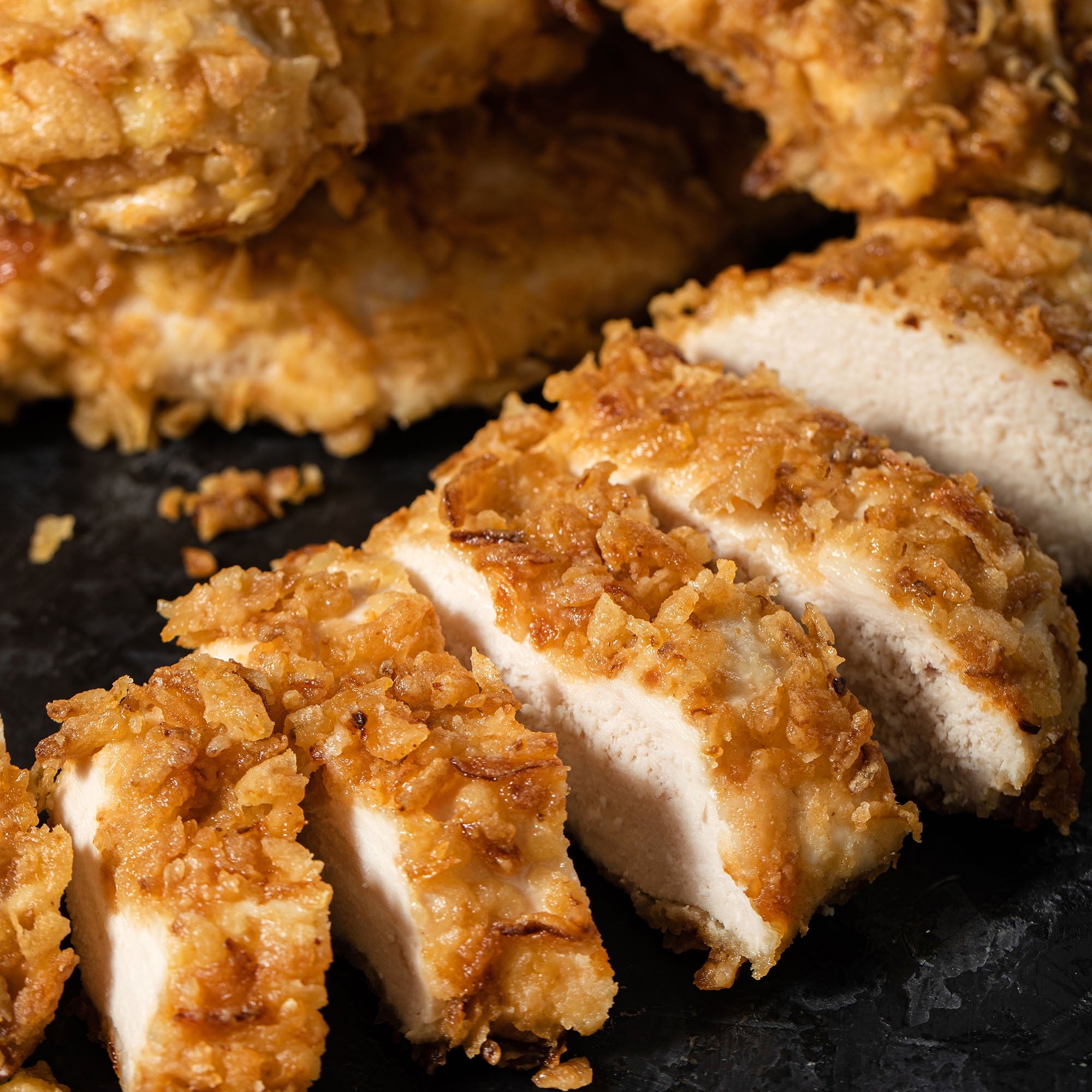 Sliced fried chicken on a dark surface