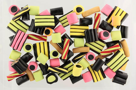 Assorted colorful licorice candy pieces on a light gray background