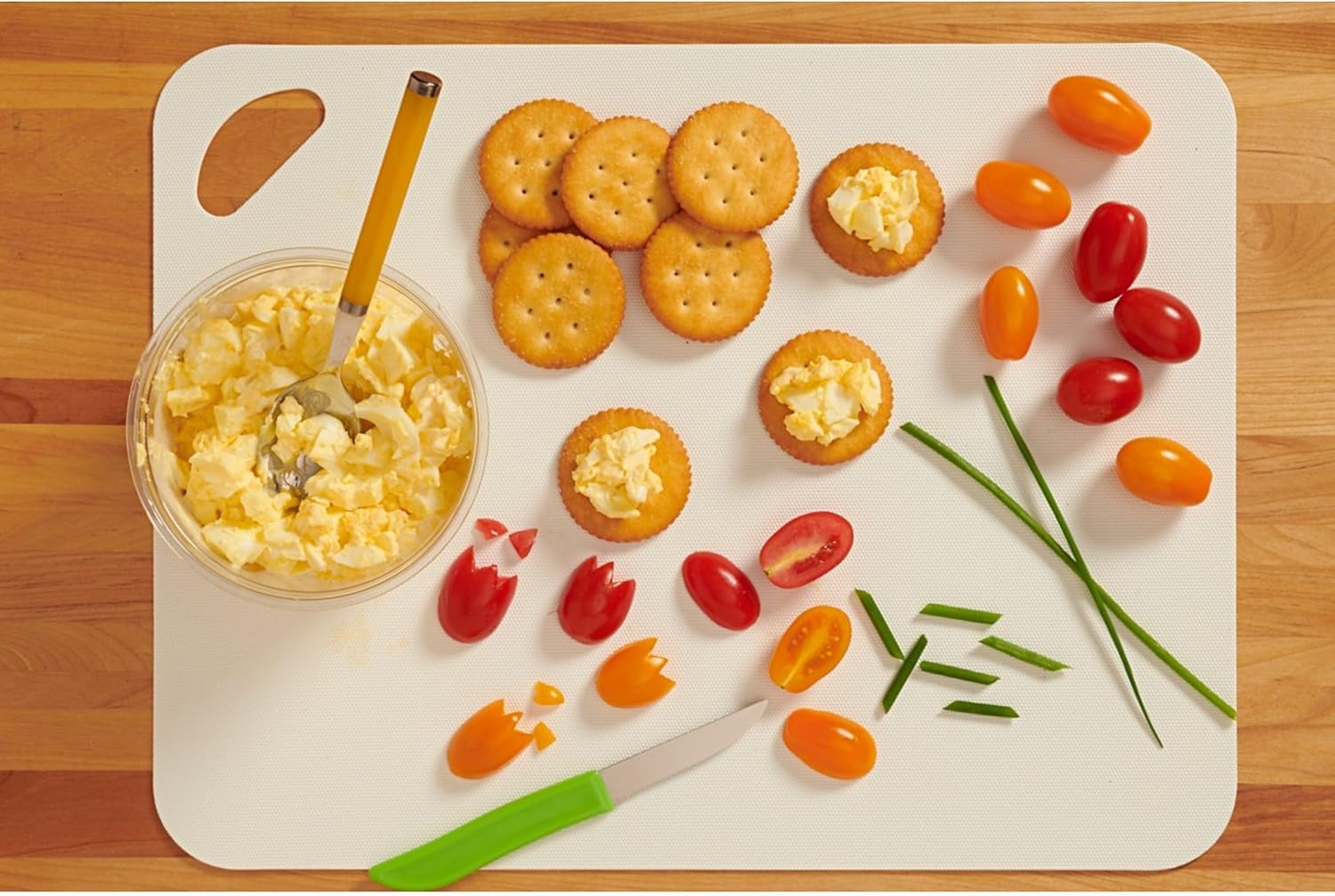 Tray with macaroni and cheese, Ritz low sodium crackers, and vegetables on a wooden surface.