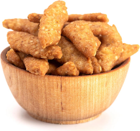 Wooden bowl filled with Yupik salted sesame sticks on a white background