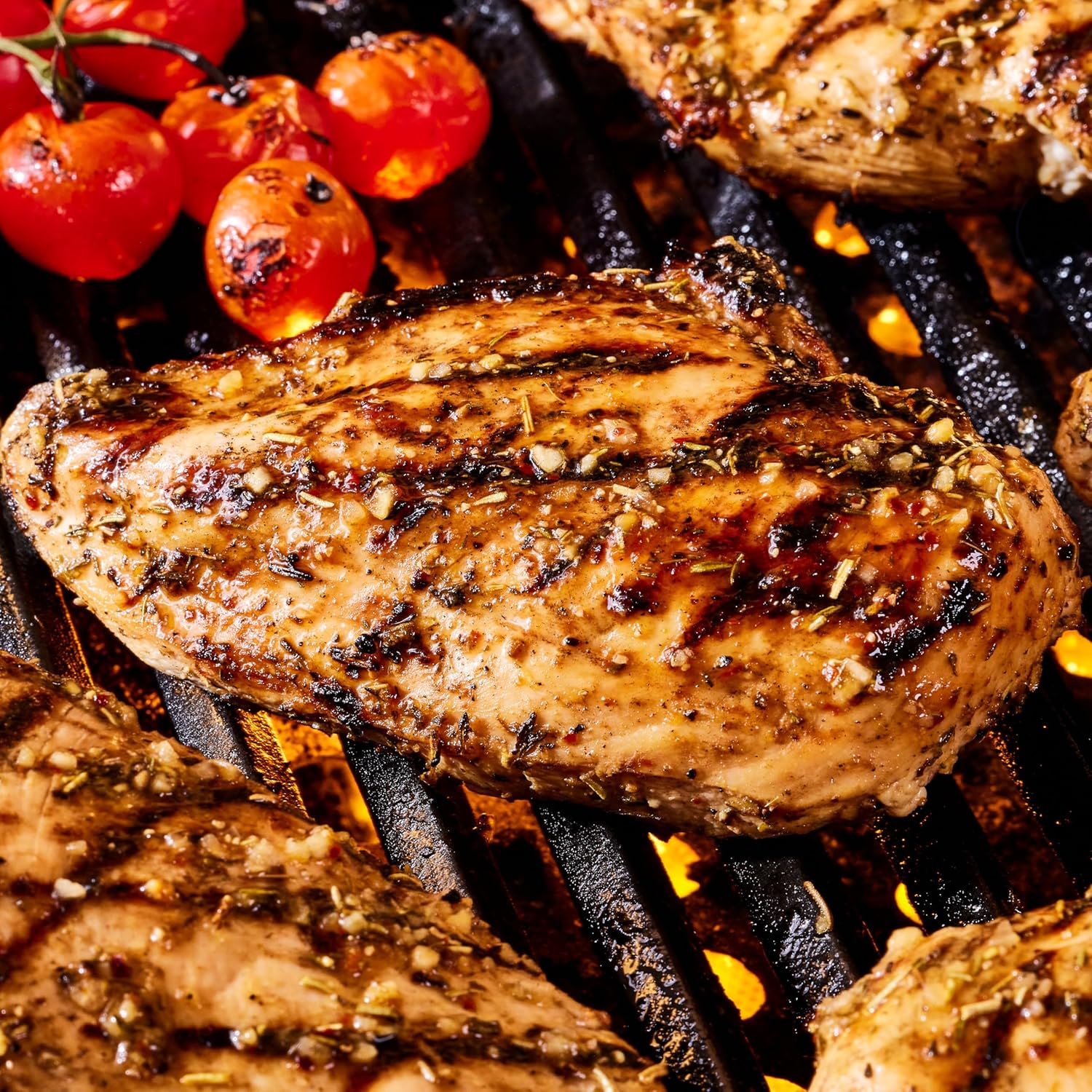 Grilled chicken breast with cherry tomatoes on a grill