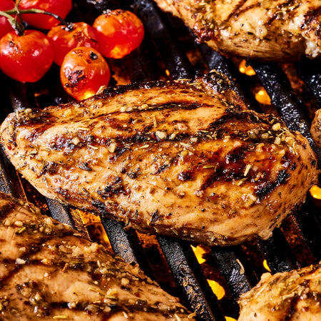 Grilled chicken breast with cherry tomatoes on a grill