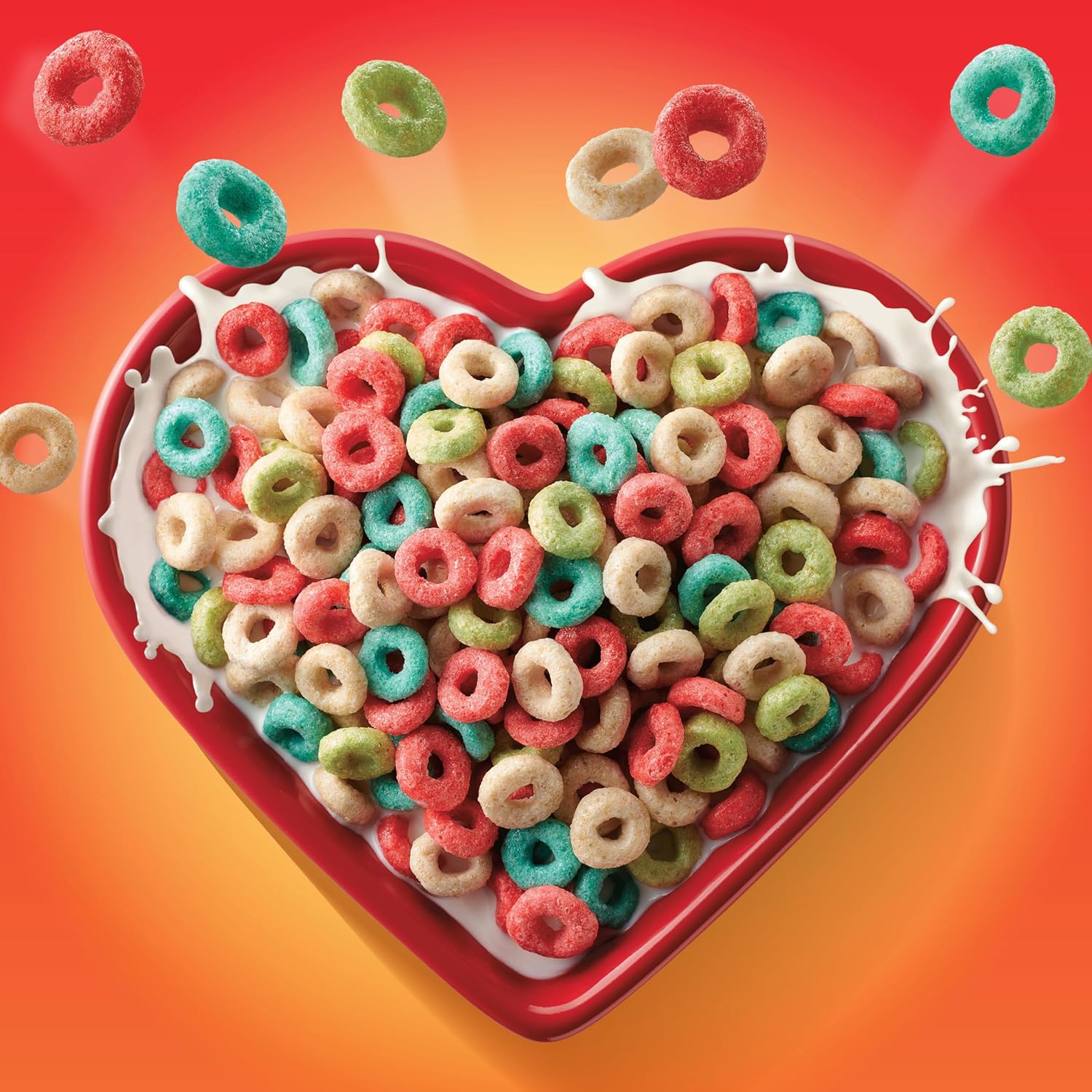 Heart-shaped bowl filled with colorful cereal loops on a vibrant red and orange background
