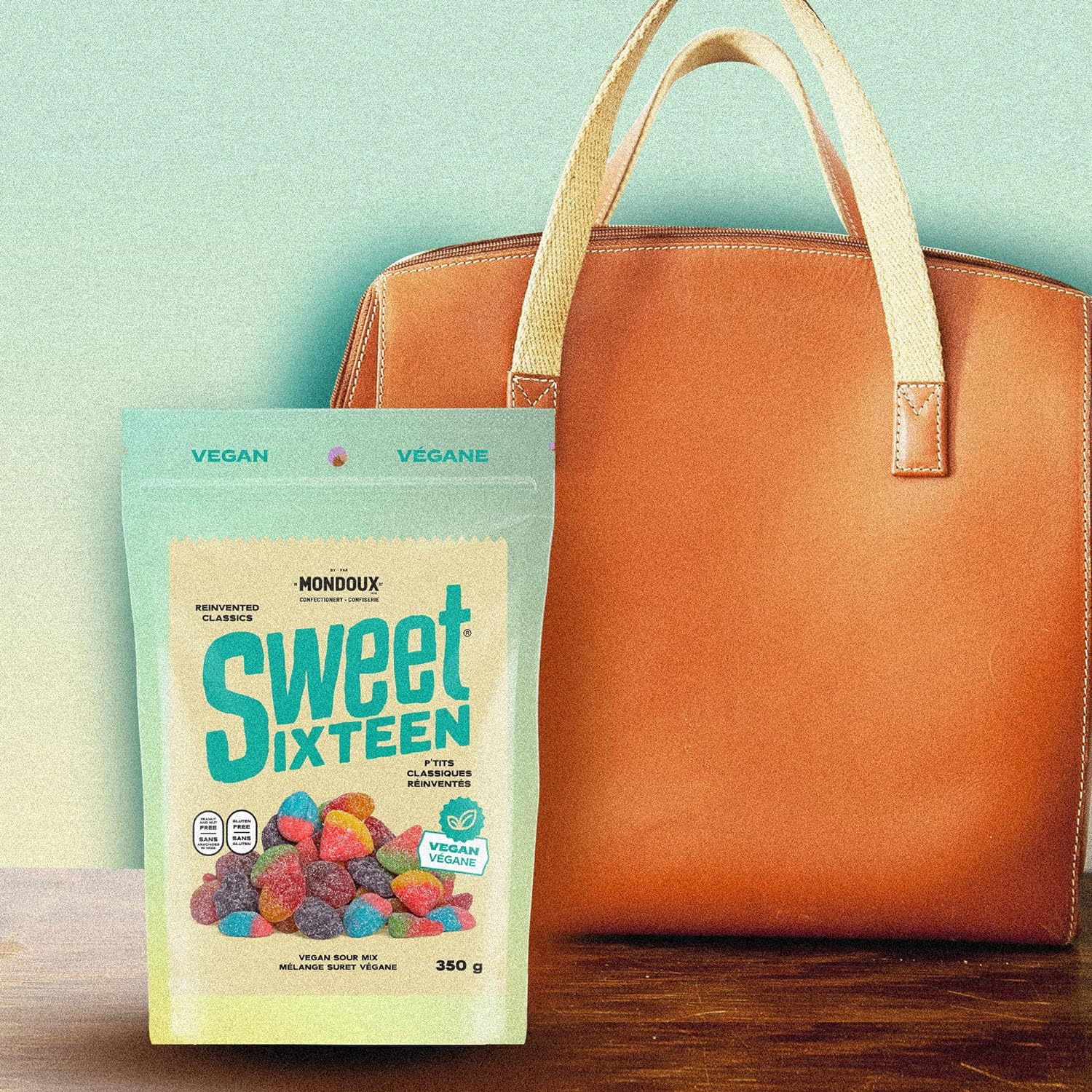 Mondoux Sweet Sixteen Vegan Sour Gummies, 350g, picture of gummy bag beside a purse.