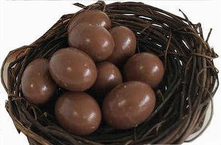 Chocolate eggs in a wicker basket on a white background