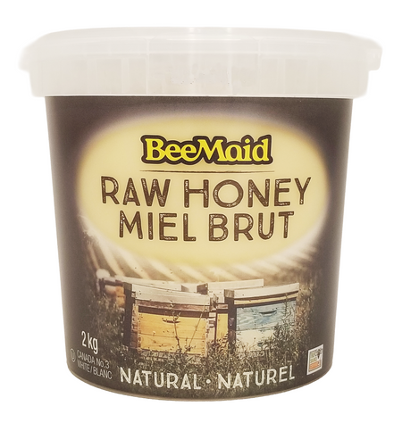 Container of BeeMaid raw honey 2kg with a bee hive image on the label.