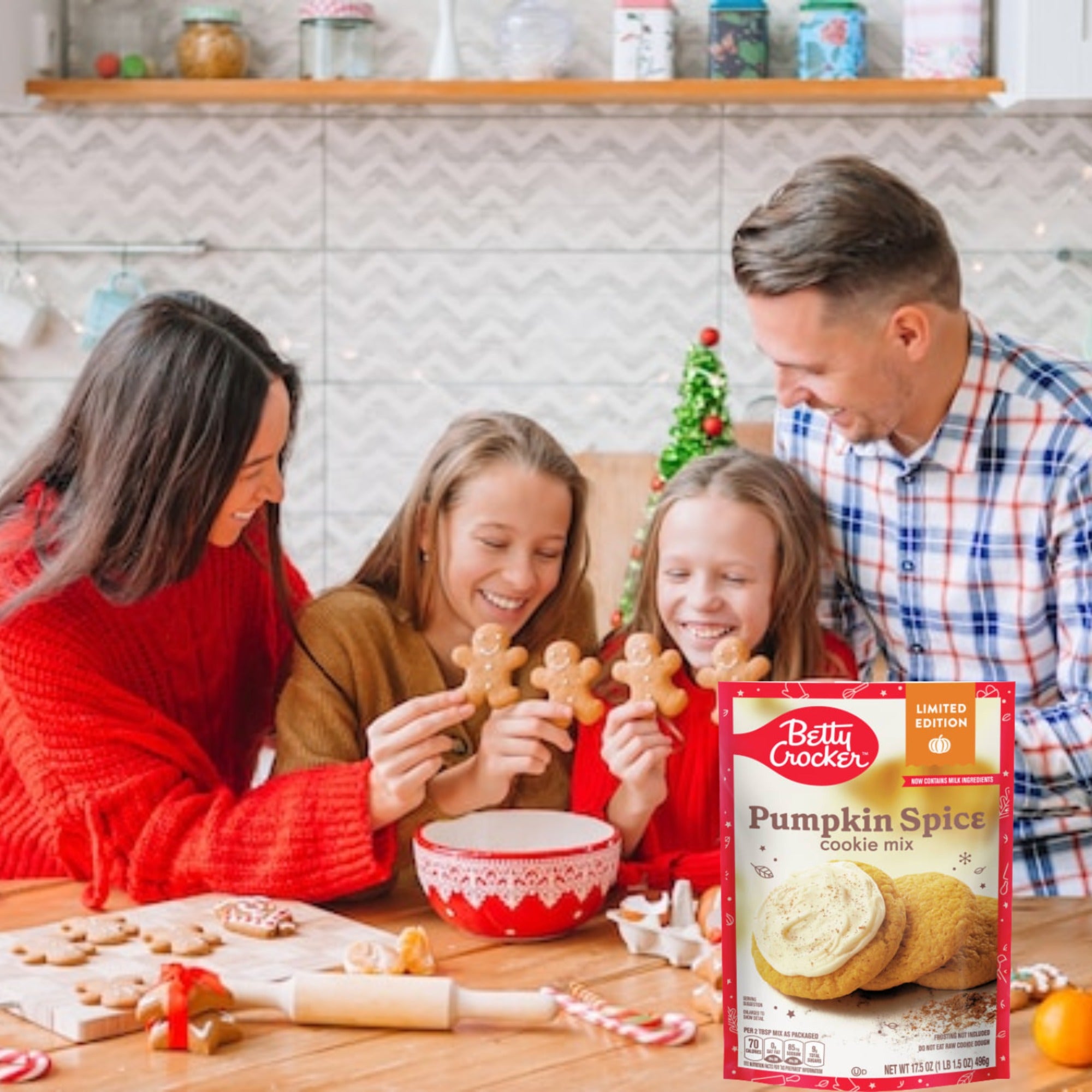 Two adults and two children holding shaped cookies beside a Betty Crocker Pumpkin Spice Cookie Mix pouch.