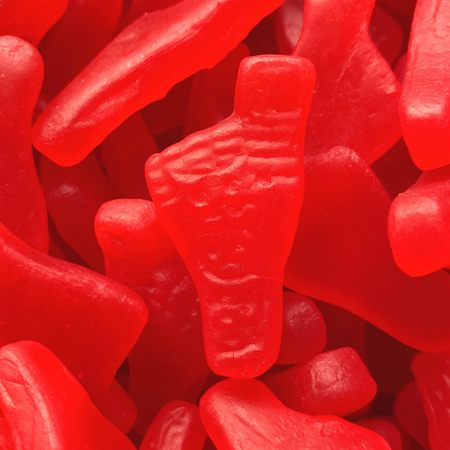 Close-up of red big foot gummy candies with a prominent foot-shaped candy in the center.