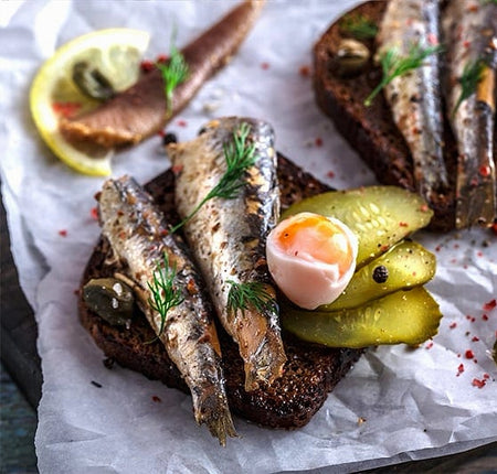 Brunswick Sardines in Spring Water plated with pickles and boiled egg — healthy seafood meal