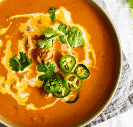  bowl of creamy soup with garnishes on a textured surface