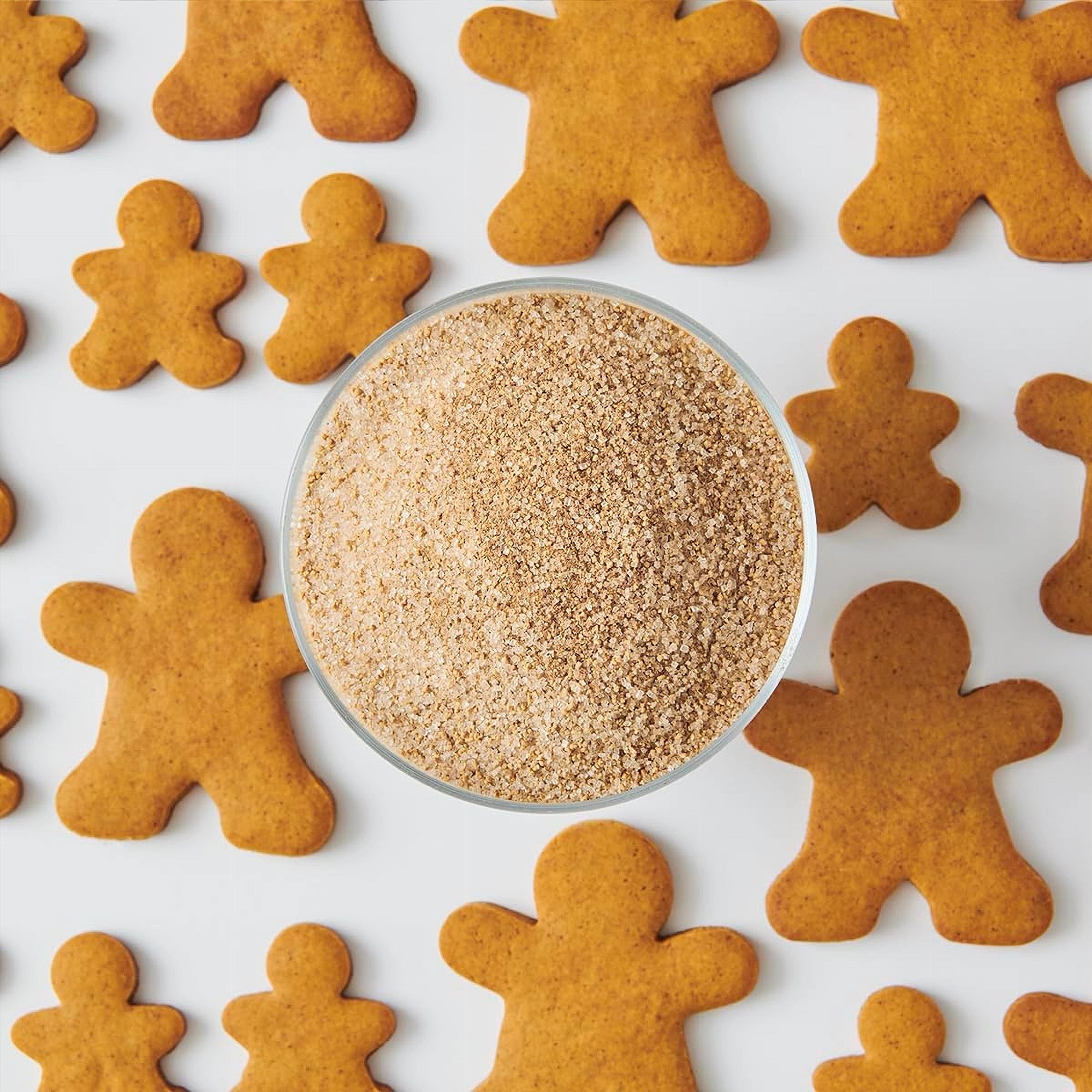 Gingerbread cookies arranged around a bowl of gingerbread crumbs on a white background