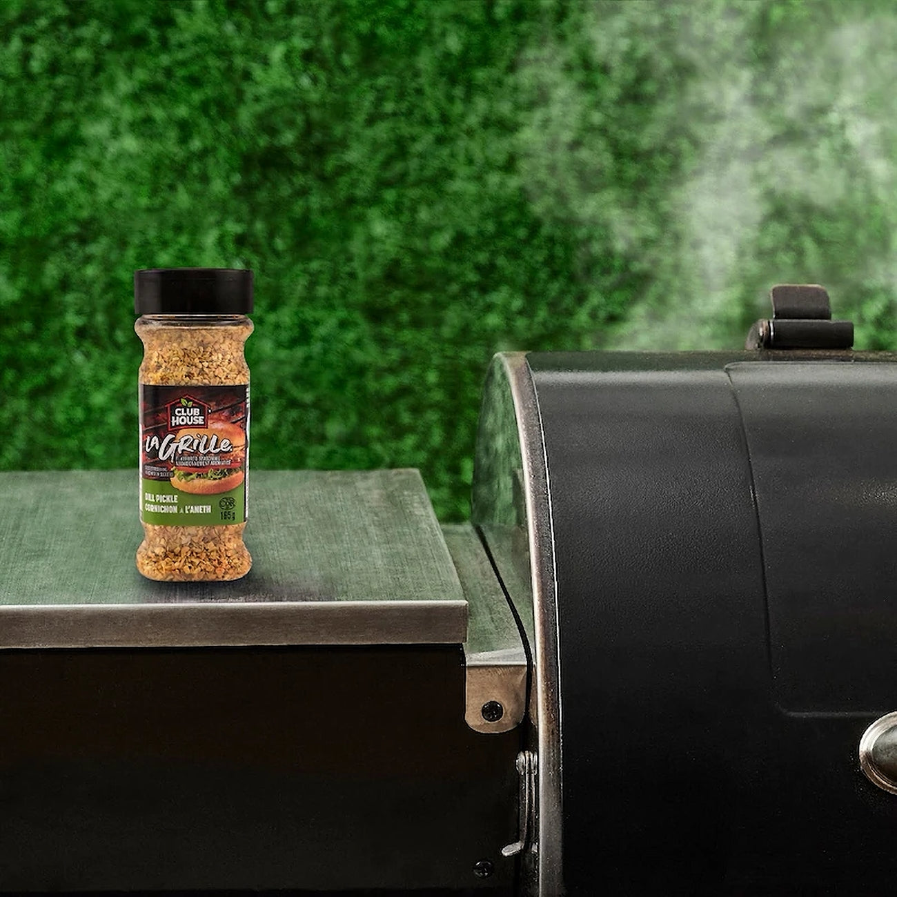 Jar of Club House La Grille Dill Pickle Seasoning on a grill with a green background