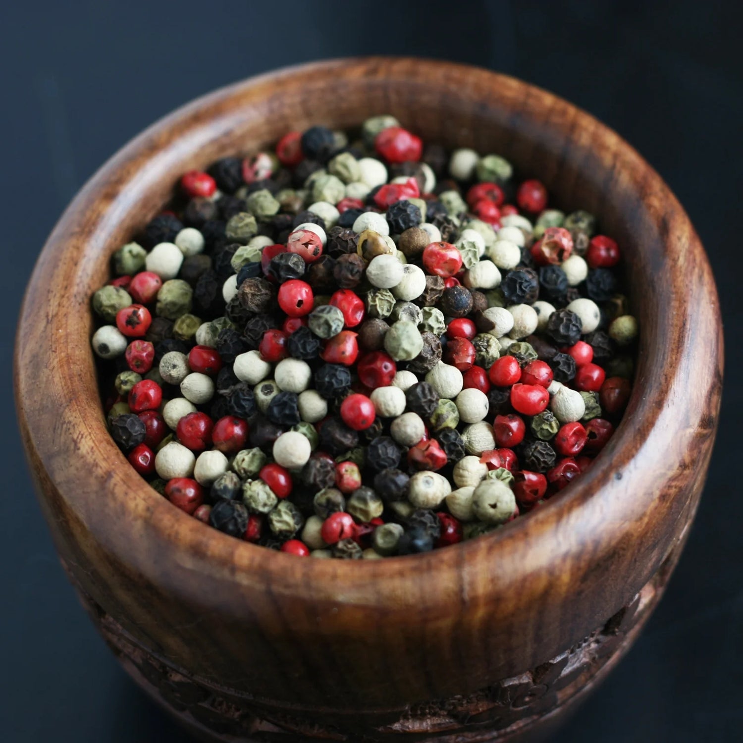 Close-up of Compliments 4 Peppercorn Blend showing whole black, white, green, and pink peppercorns