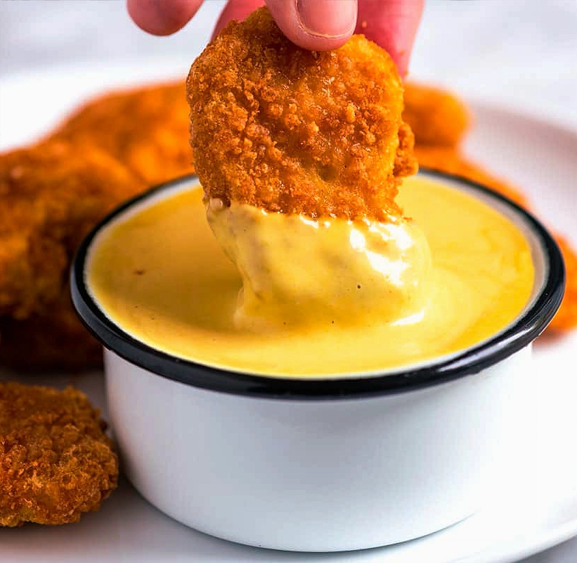 Chicken nugget dipped in Compliments Honey Mustard sauce Canadian condiment