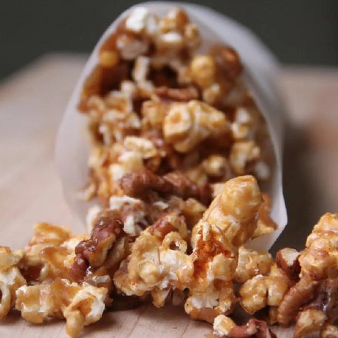 Compliments Spicy Maple Flavored Popcorn Mix, Sweet & Spicy Popcorn Snack 200g/7.1 oz spilling out of a white bag on a wooden surface