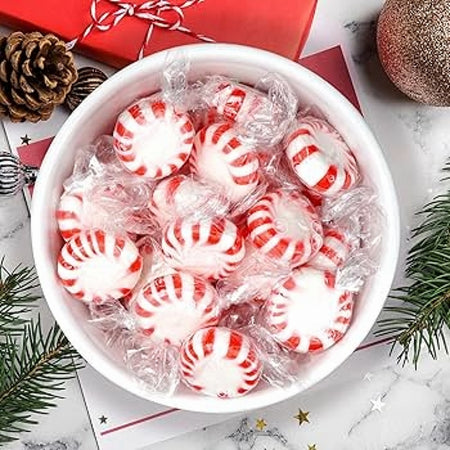 Bowl of Cottage Country red striped peppermint mints with holiday Christmas decorations
