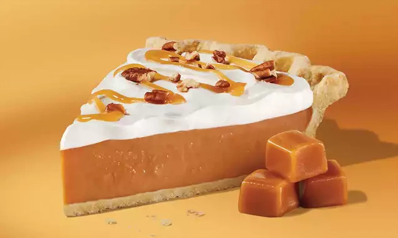 Slice of butterscotch pie with whipped cream and caramel drizzle on a yellow background