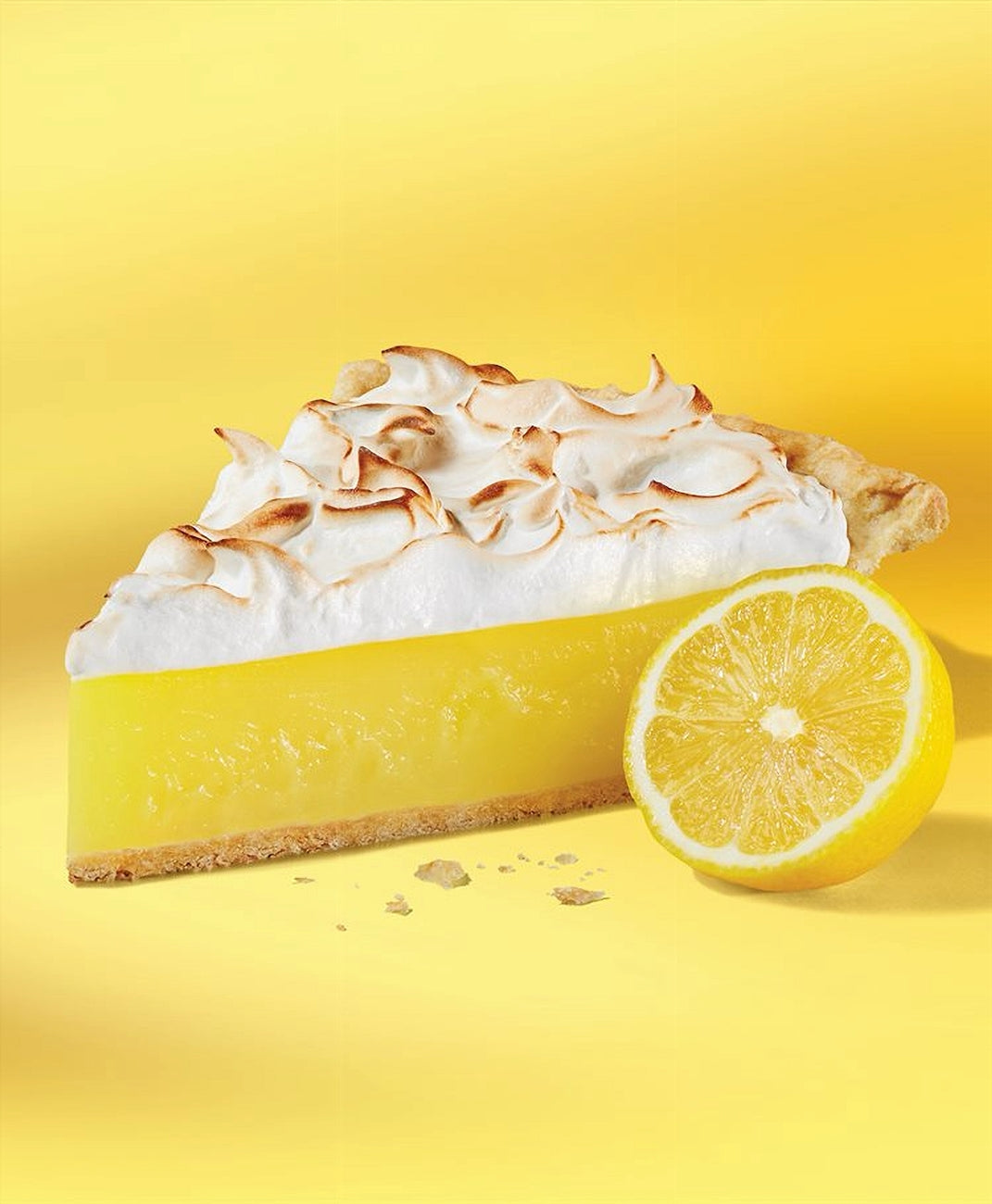 Lemon meringue pie with a lemon on a yellow background