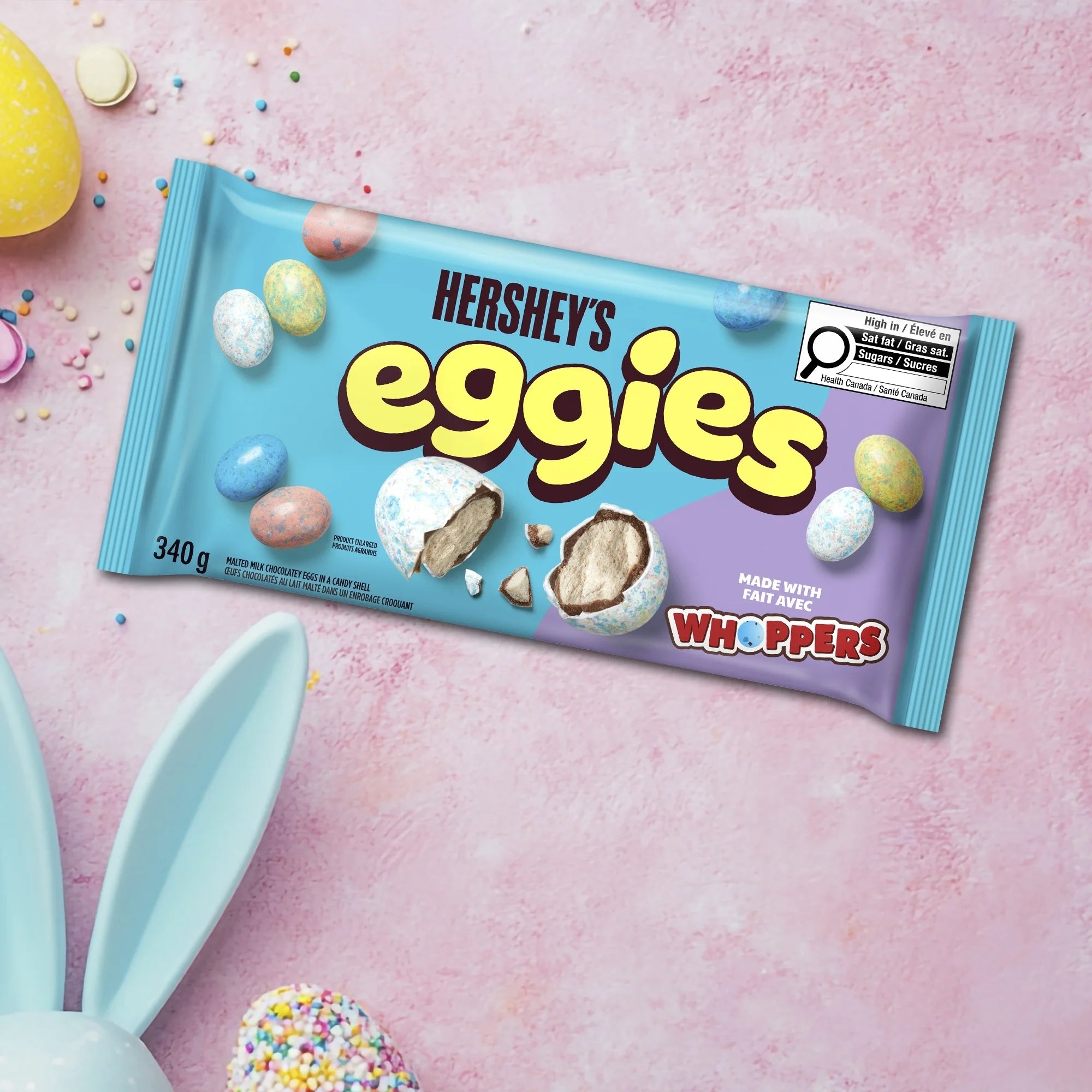 Hershey's Eggies candy package with Easter-themed elements on a pink background