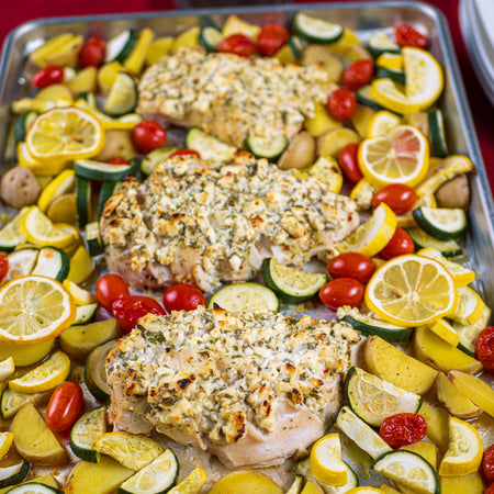 Sheet pan baked chicken breasts coated in Kinder's Buttery Steakhouse Seasoning with zucchini, cherry tomatoes, and lemon