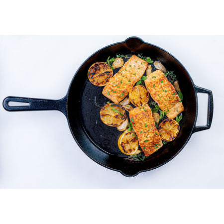 Salmon fillets with caramelized lemon and herbs in a cast iron skillet, seasoned with Kinder's Caramelized Onion Butter dry rub