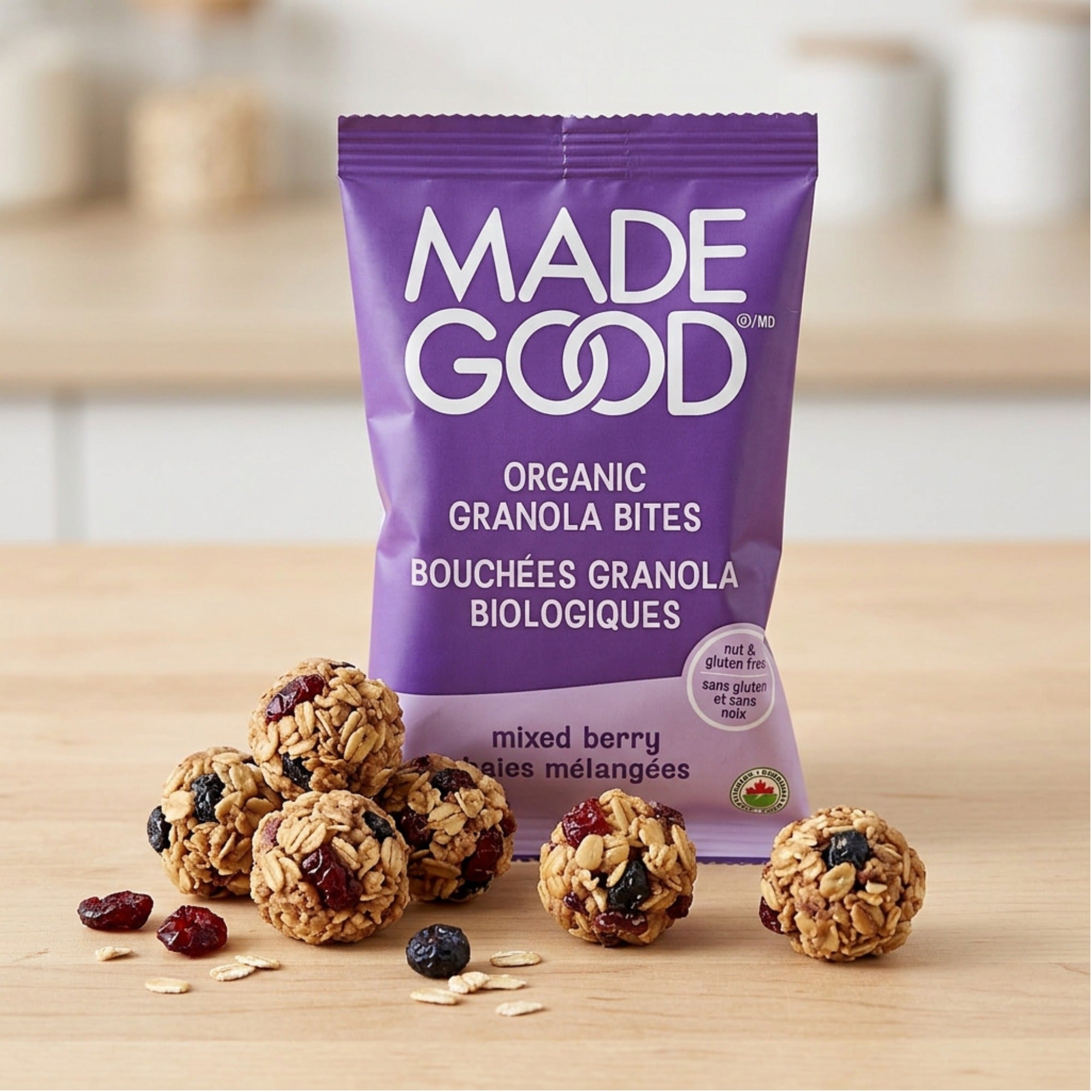 MadeGood Mixed Berry Granola Bites pouch with oat-and-fruit clusters on a wooden surface.