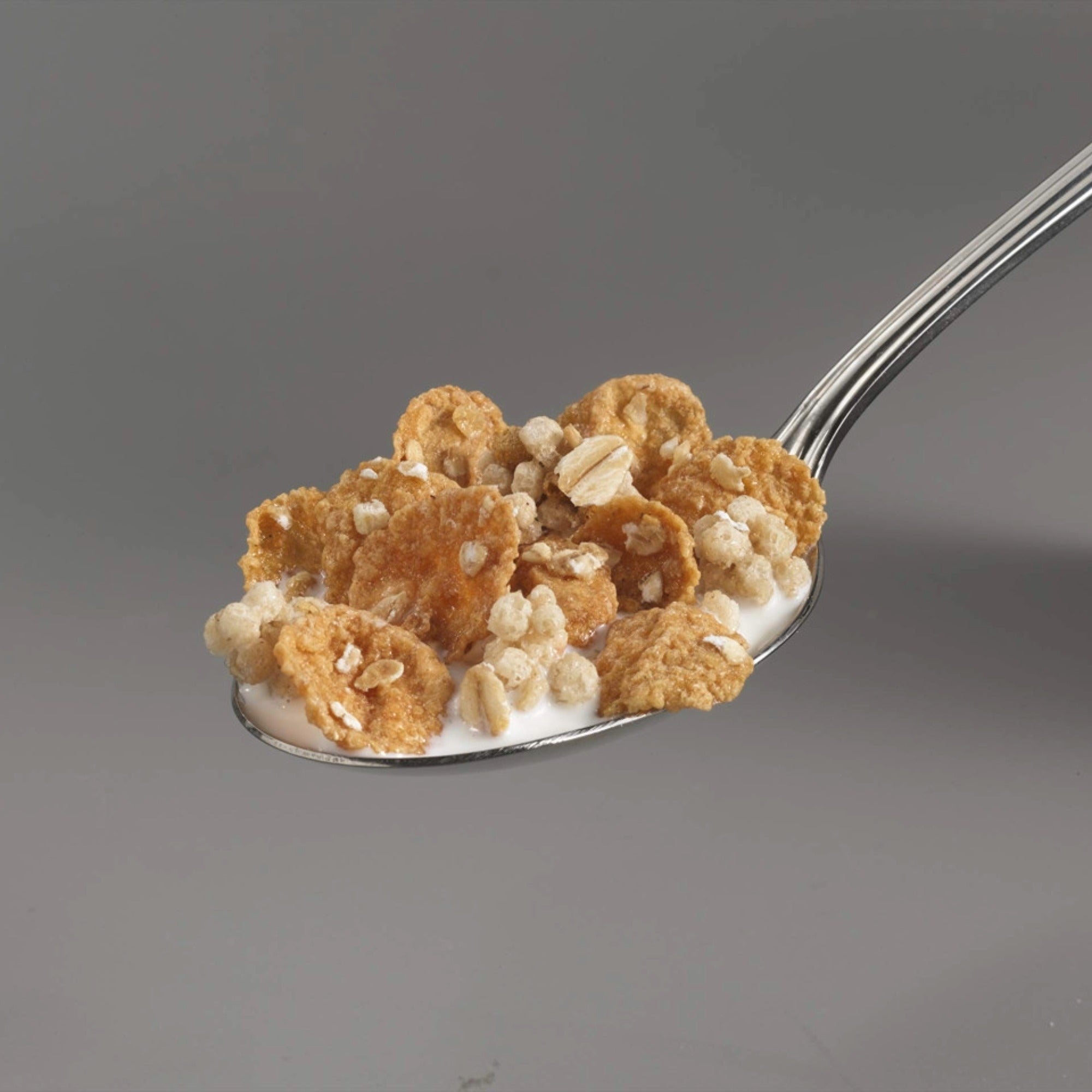 A spoon full of Oatmeal Crisp maple nut cereal with milk.