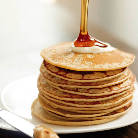 Our Finest Very Dark Maple Syrup poured over pancakes — bold Canadian maple syrup