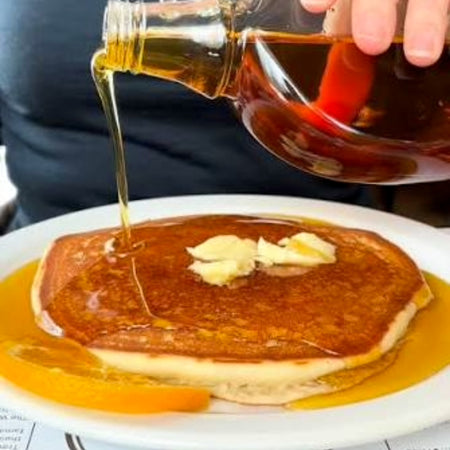 Our Finest Amber Maple Syrup drizzled over pancakes — pure Canadian maple syrup
