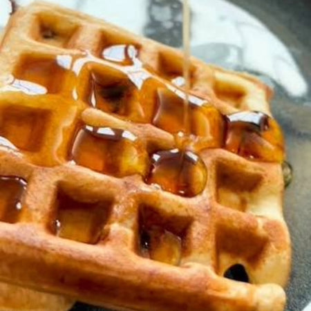 Our Finest Amber Maple Syrup poured over waffles — rich Canadian amber maple syrup