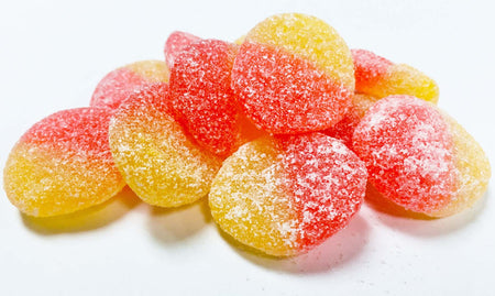 A pile of Allan Peach Slices Gummy Candy on a white background