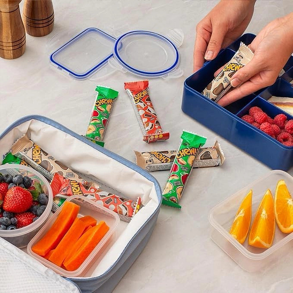 Lunch preparation with various snacks and fruits on a white surface