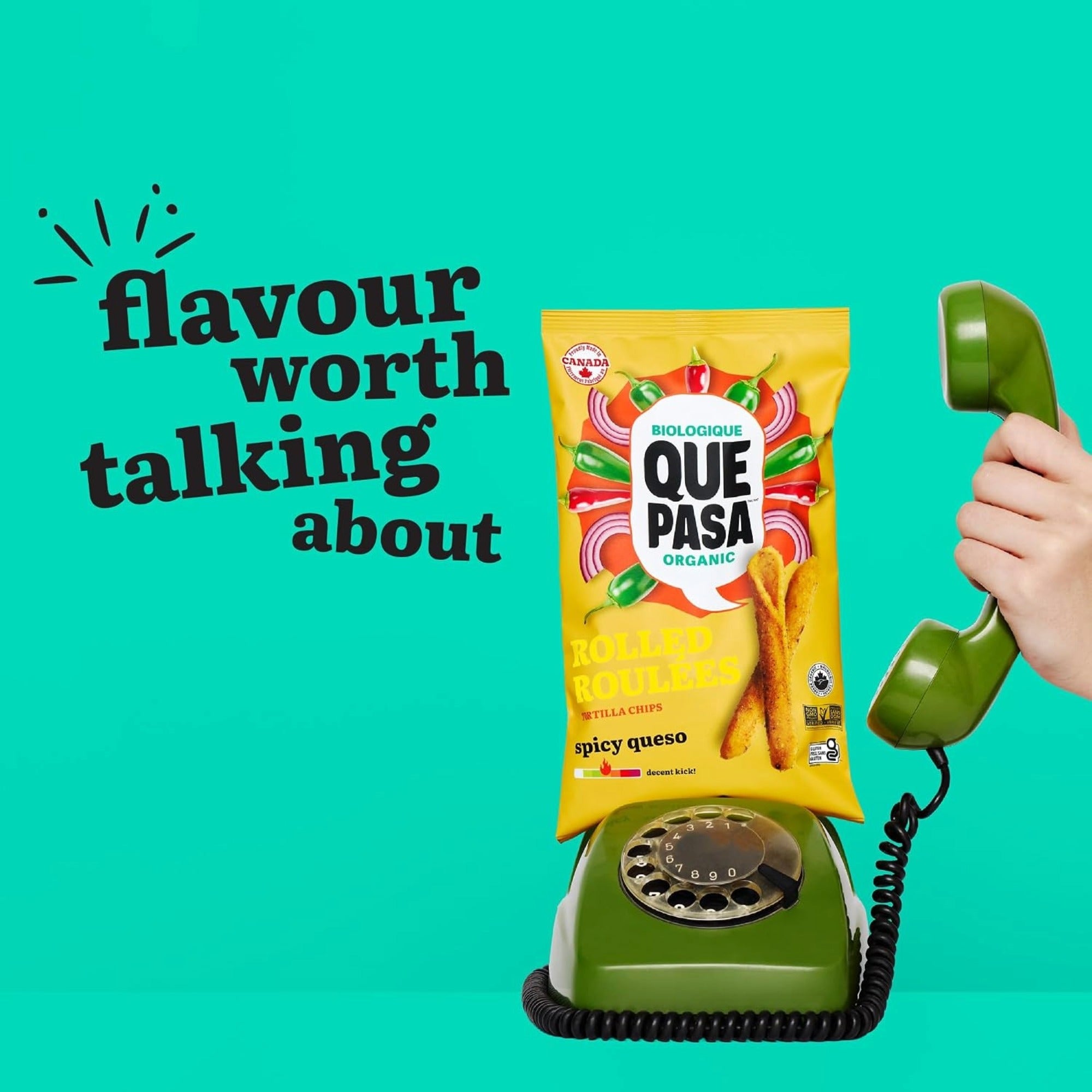 Que Pasa Spicy Queso rolled chip bag on a green rotary phone beside “flavour worth talking about.