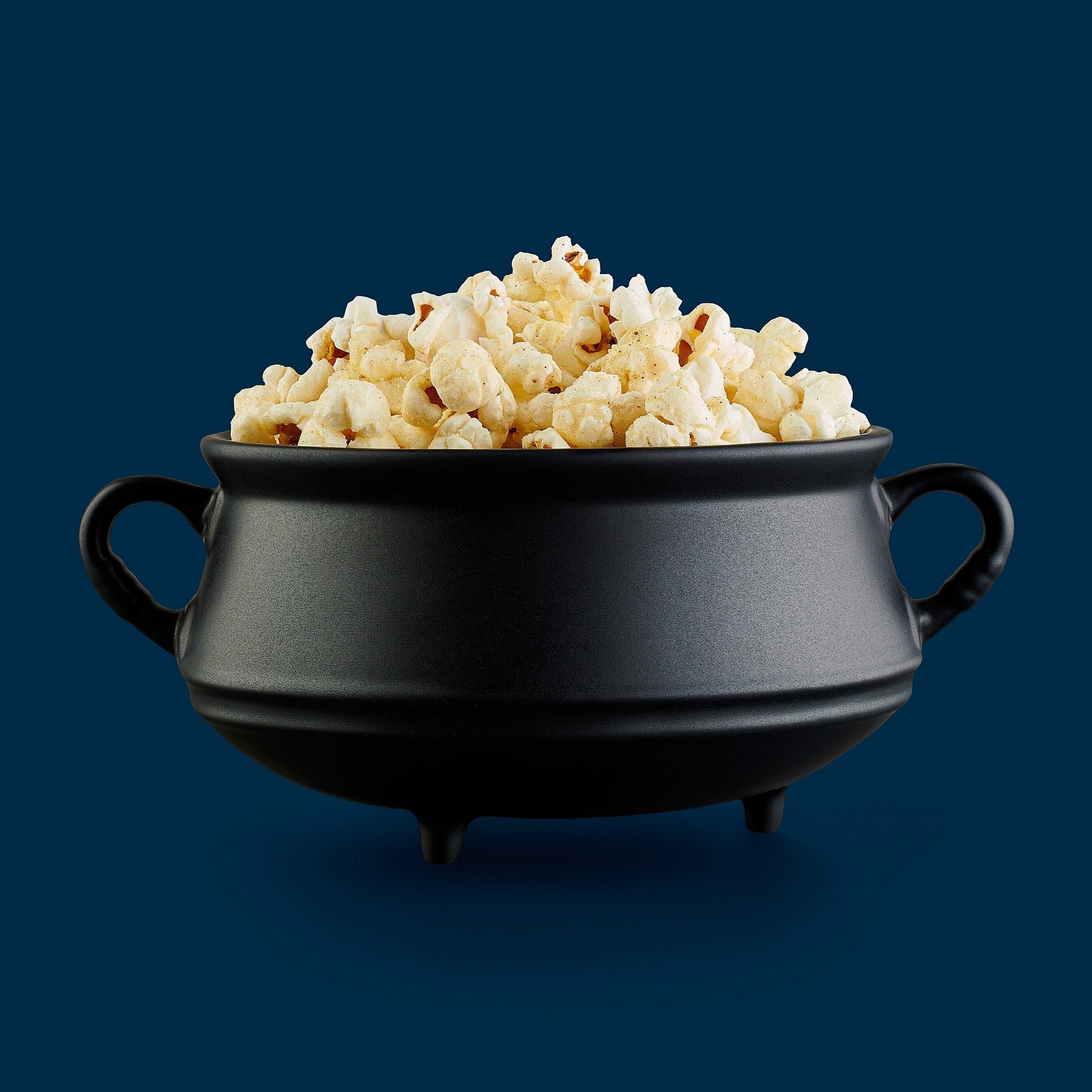 Black cast iron pot filled with popcorn 