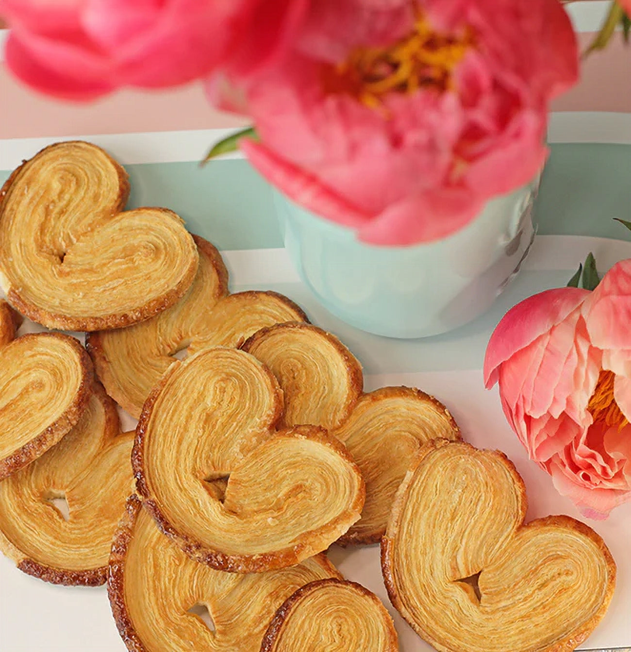 Heart-shaped Palmiers cookies with pink flowers in the background