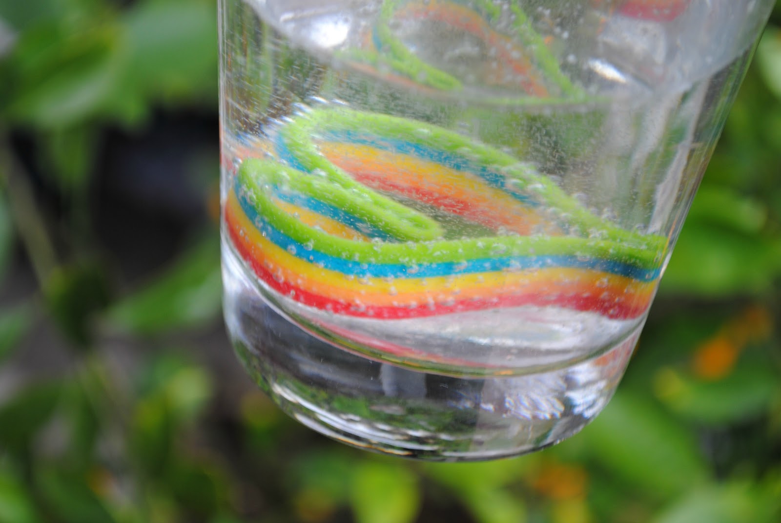 Huer Sour Rainbow Steamers Gummy Candy, 70g/2.5 oz., heart shaped sour rainbow streamer in a glass with fizzy water.